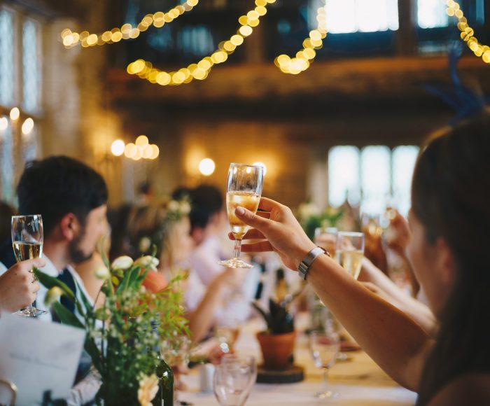 People are lifting their glass of bubbly while attending a ceremony